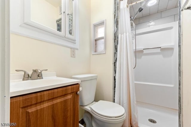 bathroom with a stall shower, toilet, and vanity