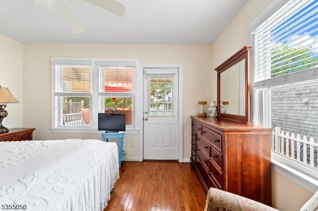 bedroom with multiple windows, hardwood / wood-style flooring, ceiling fan, and baseboards