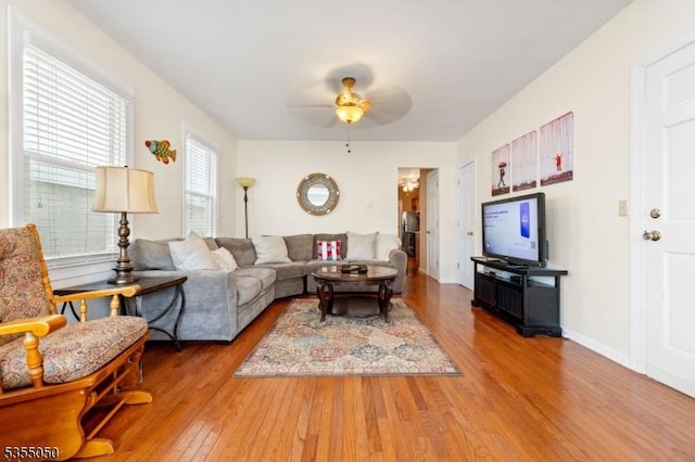 living room with wood finished floors, ceiling fan, and baseboards