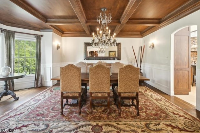 dining room featuring wood ceiling, wood finished floors, a chandelier, arched walkways, and ornamental molding