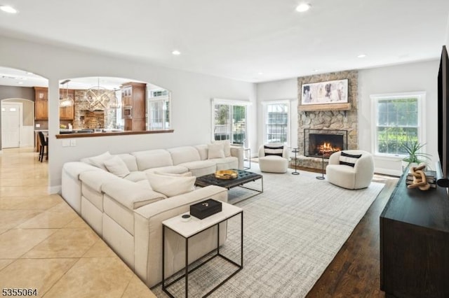 living area featuring arched walkways, recessed lighting, and a fireplace
