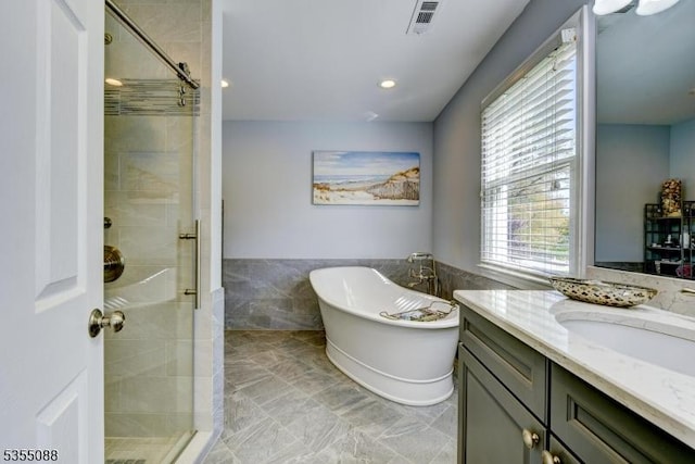 bathroom with vanity, visible vents, wainscoting, a freestanding bath, and a stall shower