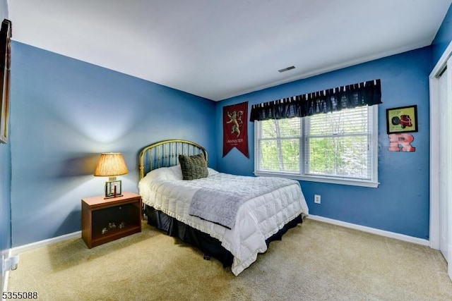 bedroom with baseboards, visible vents, and carpet
