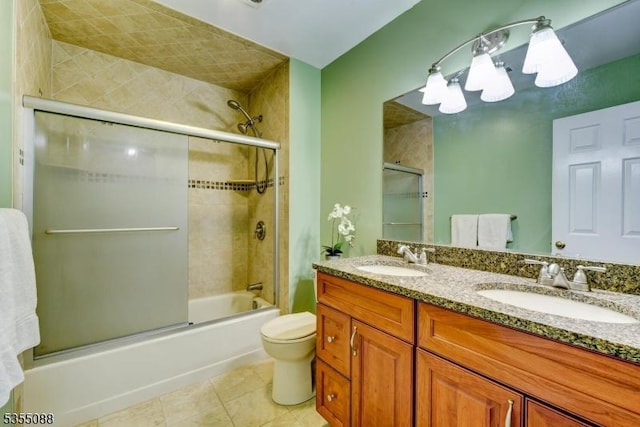 bathroom with toilet, tile patterned floors, combined bath / shower with glass door, and a sink