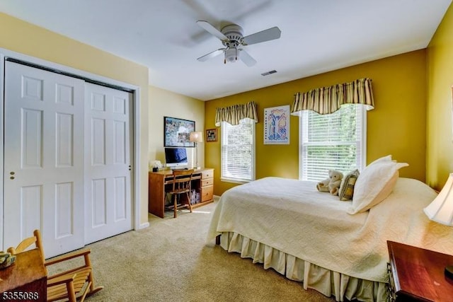 carpeted bedroom featuring ceiling fan, a closet, and visible vents