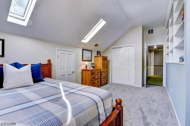 carpeted bedroom featuring visible vents, baseboards, vaulted ceiling with skylight, and a closet