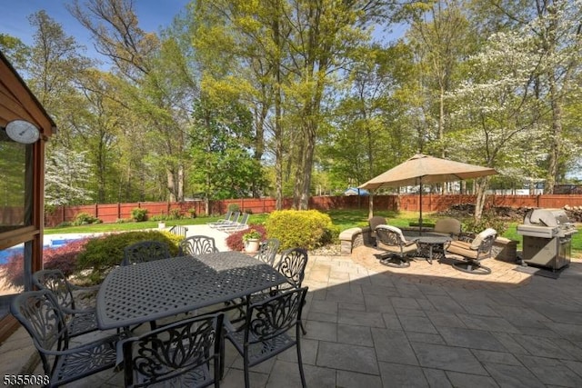 view of patio / terrace with a fenced backyard, outdoor dining space, and a grill
