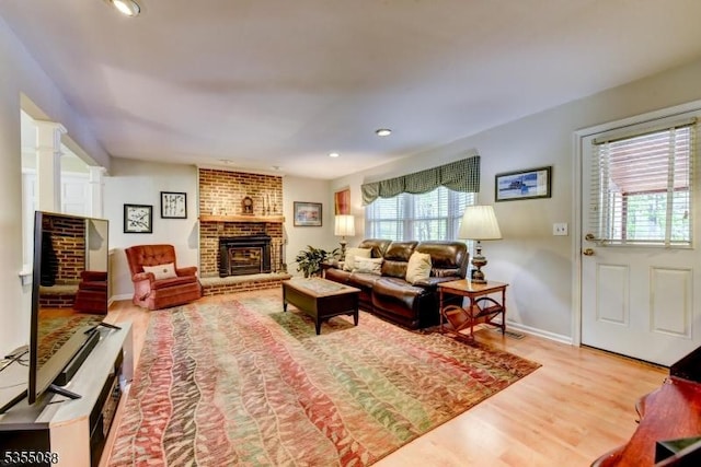 living area featuring recessed lighting, baseboards, wood finished floors, and a fireplace
