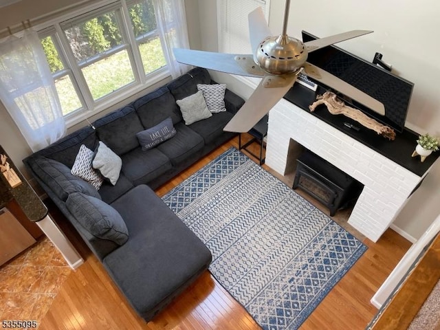 living area with baseboards, wood finished floors, and a fireplace