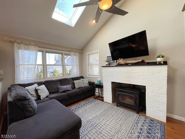 living room with plenty of natural light, a ceiling fan, baseboards, and high vaulted ceiling