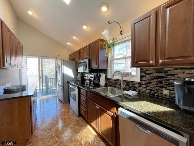 kitchen with backsplash, vaulted ceiling, a sink, stainless steel appliances, and recessed lighting