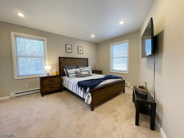 bedroom with light carpet, baseboards, baseboard heating, recessed lighting, and a baseboard heating unit