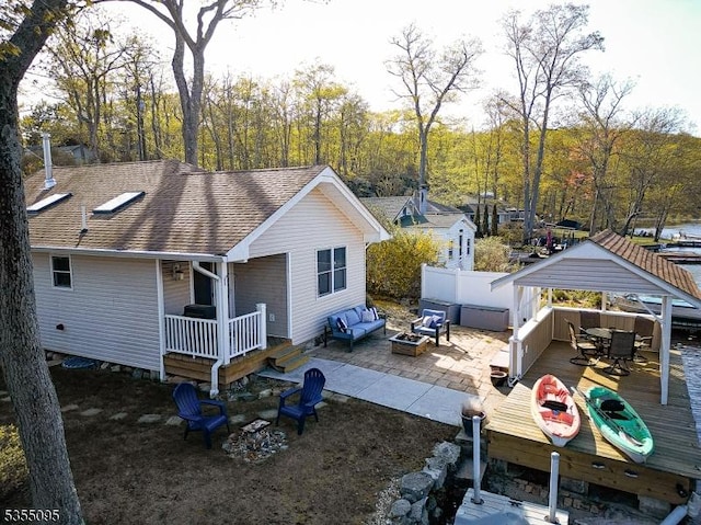 view of side of property with a wooden deck, fence, roof with shingles, a gazebo, and outdoor dining space