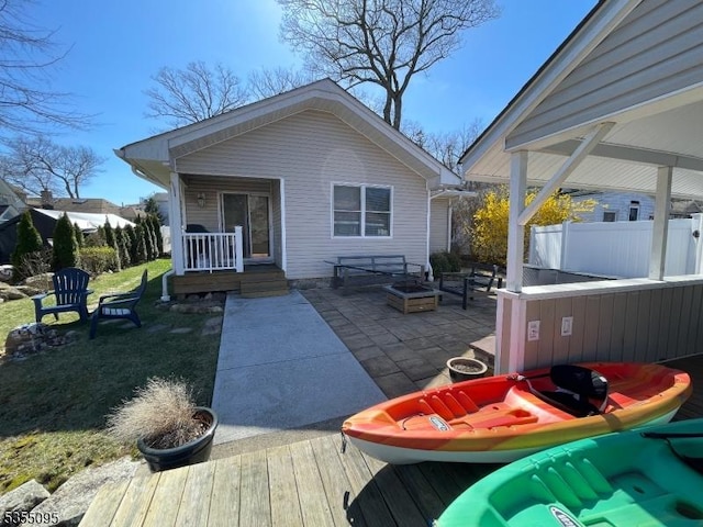 back of property with fence and a patio