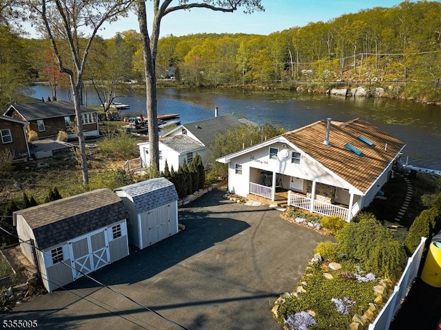 drone / aerial view with a water view and a forest view
