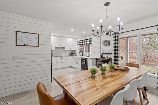 dining room with a healthy amount of sunlight, an inviting chandelier, and light wood finished floors