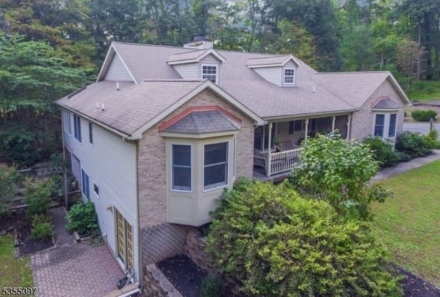 view of front of house with brick siding, a chimney, and a garage