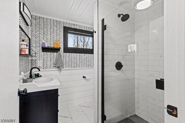 full bathroom with vanity, marble finish floor, a stall shower, and wallpapered walls