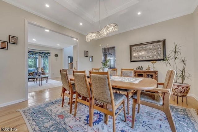 dining area with recessed lighting, an inviting chandelier, ornamental molding, and light wood-style floors