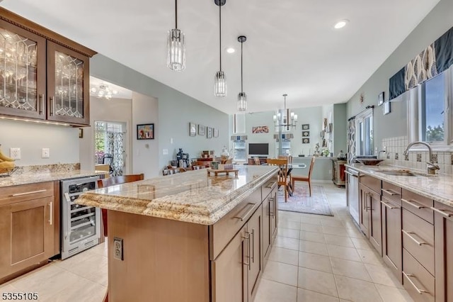 kitchen with an inviting chandelier, beverage cooler, light stone counters, a sink, and light tile patterned floors
