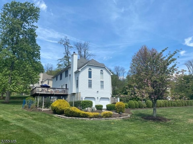 view of property exterior with a lawn, a deck, an attached garage, and a chimney