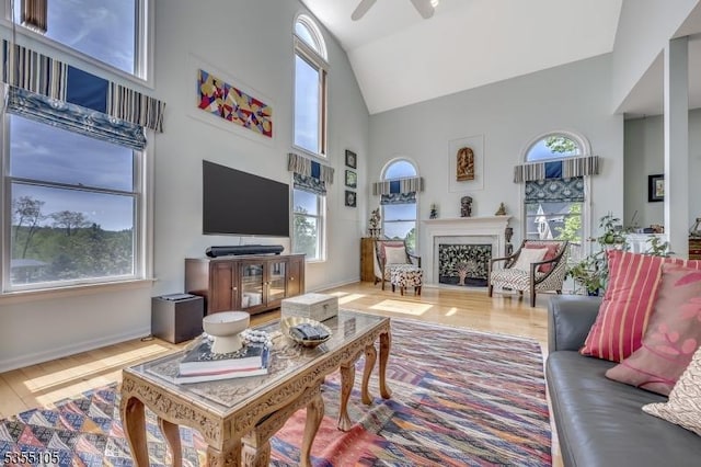 living area featuring high vaulted ceiling, a wealth of natural light, and wood finished floors
