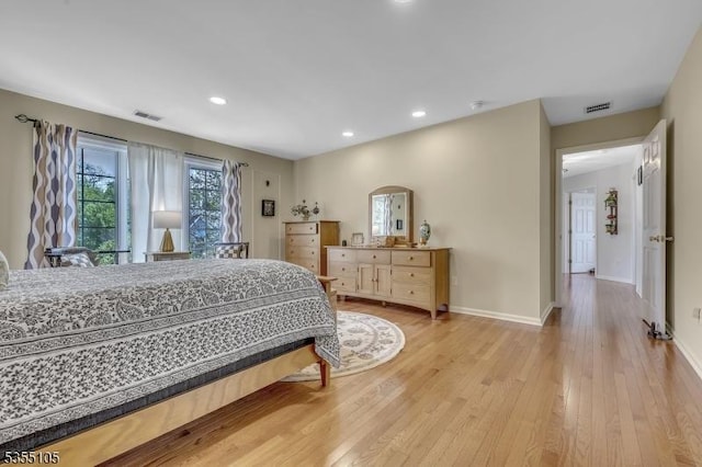 bedroom featuring baseboards, light wood-type flooring, and visible vents