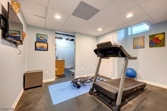 workout area with baseboards, carpet floors, and a paneled ceiling
