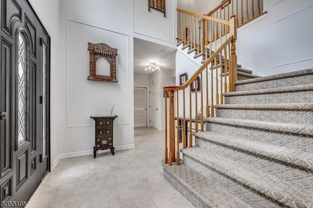 entrance foyer with stairs and baseboards