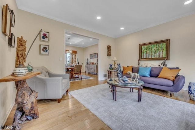 living area featuring recessed lighting, ornamental molding, and light wood-style floors