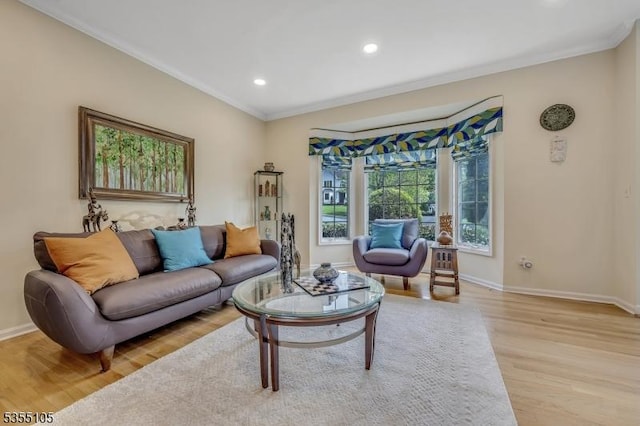living room with crown molding, recessed lighting, baseboards, and light wood-style floors