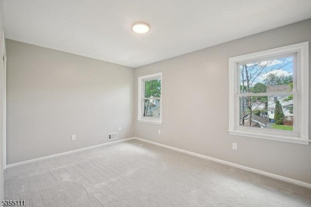 spare room with baseboards and carpet flooring