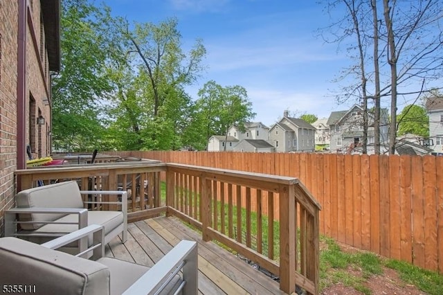 wooden deck featuring a fenced backyard and a residential view