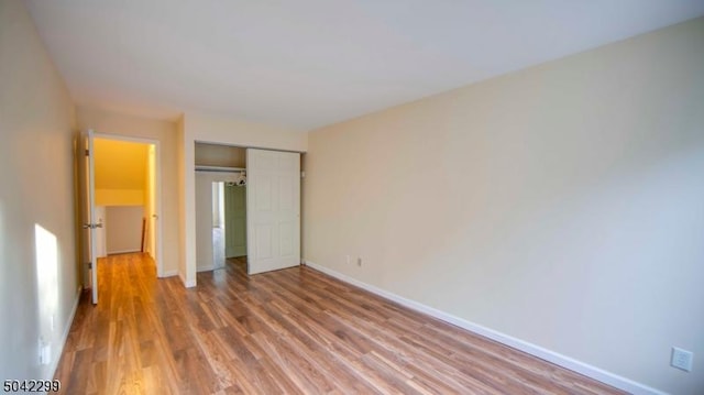 unfurnished bedroom with a closet, light wood finished floors, and baseboards