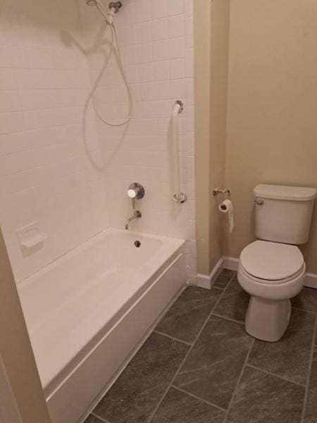 full bathroom with toilet, baseboards, tile patterned flooring, and bathtub / shower combination