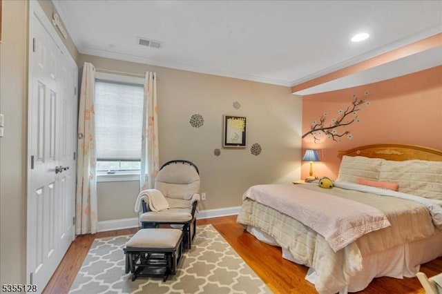 bedroom with ornamental molding, wood finished floors, baseboards, and recessed lighting
