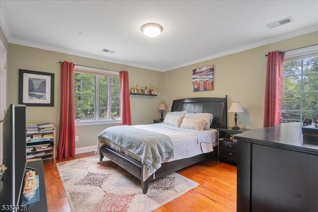 bedroom featuring multiple windows, light wood-type flooring, crown molding, and baseboards