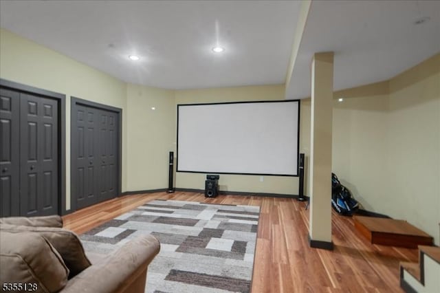 cinema featuring light wood finished floors, recessed lighting, and baseboards