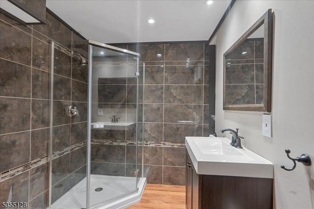 bathroom featuring a stall shower, vanity, tile walls, and recessed lighting