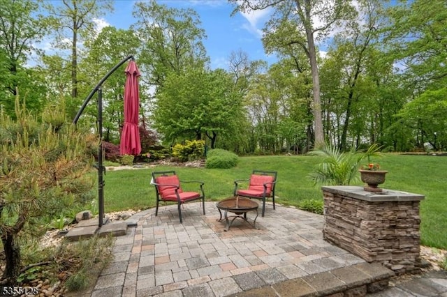 view of patio featuring a fire pit and view of scattered trees
