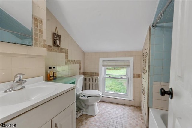 bathroom featuring tile walls, vaulted ceiling, toilet, vanity, and tile patterned flooring