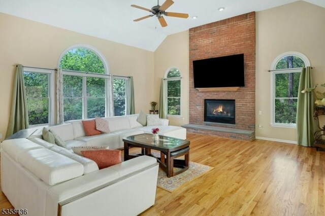 63 Twin Oaks Rd, Bridgewater Twp, NJ 08807 - living room with high vaulted ceiling, a fireplace, ceiling fan, light wood-style flooring, and baseboards