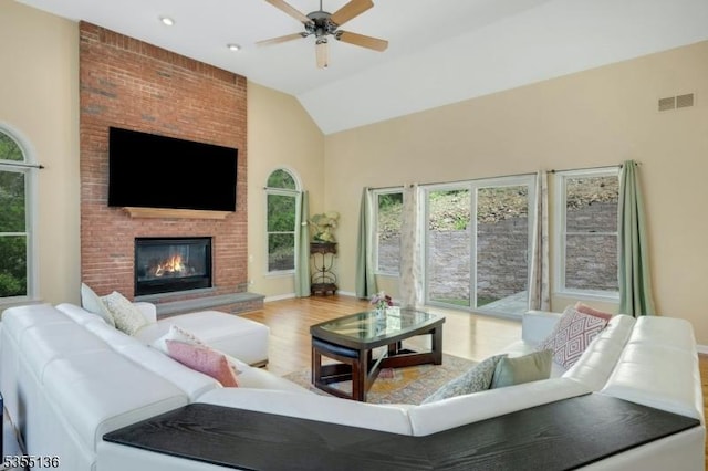 63 Twin Oaks Rd, Bridgewater Twp, NJ 08807 - living area with wood finished floors, a ceiling fan, high vaulted ceiling, a brick fireplace, and visible vents