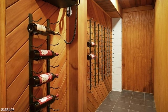 63 Twin Oaks Rd, Bridgewater Twp, NJ 08807 - wine room with dark tile patterned flooring, wood walls, and wood ceiling