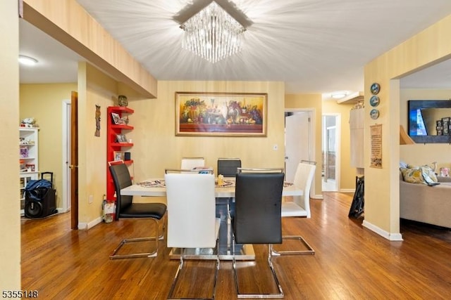 dining room with baseboards, wood finished floors, and a chandelier