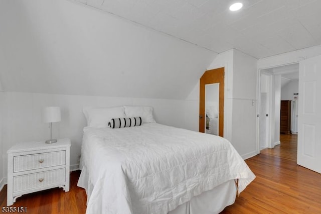 bedroom featuring recessed lighting, wood finished floors, and vaulted ceiling
