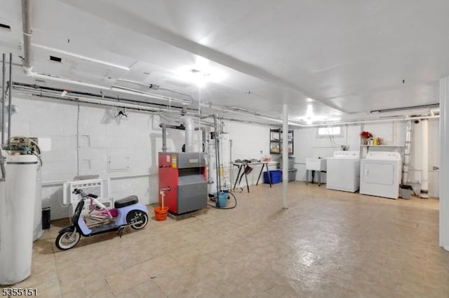 below grade area featuring gas water heater, washer and clothes dryer, a sink, water heater, and a heating unit