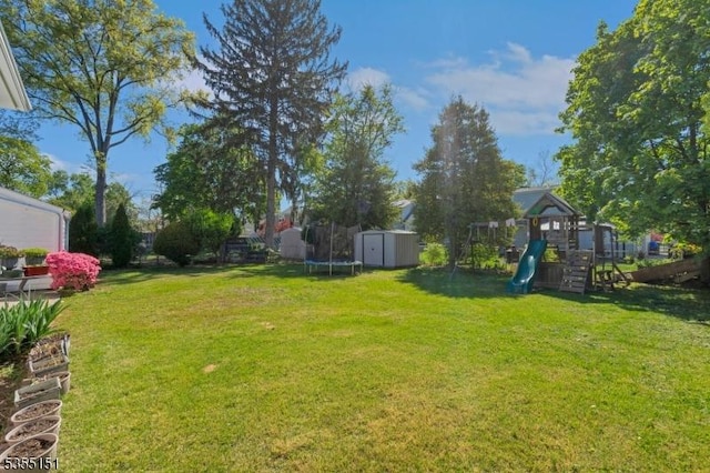view of yard featuring an outdoor structure, a trampoline, a playground, and a storage shed