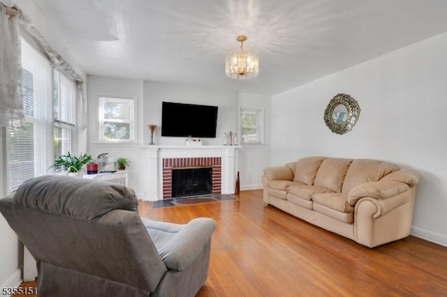 living room with baseboards, a chandelier, wood finished floors, and a wealth of natural light