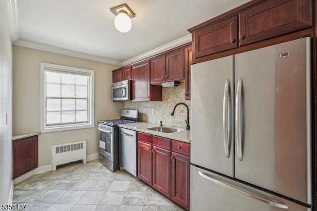 kitchen featuring stainless steel appliances, a sink, radiator heating unit, and reddish brown cabinets